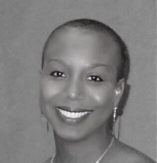The image shows a black and white portrait of a smiling woman with short hair. She is wearing earrings and a necklace with large beads or ornaments. Her smile is warm, and she has an overall calm and pleasant expression.