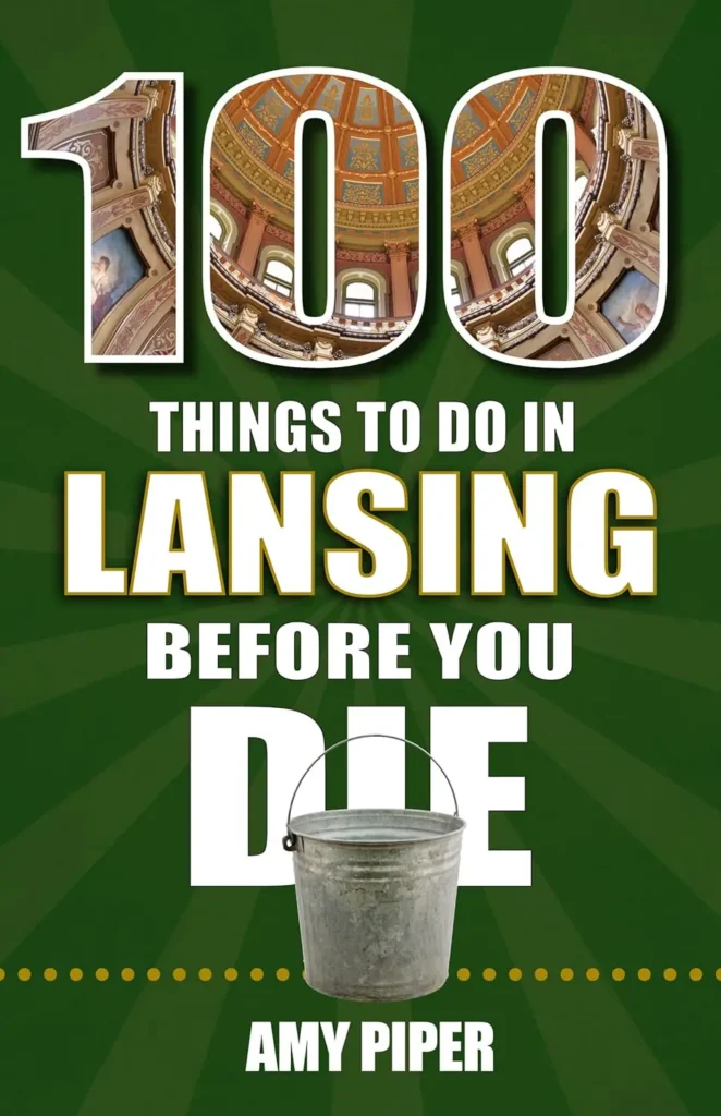 Book cover featuring "100 Things to Do in Lansing Before You Die" by Amy Piper, with a dome interior photo and a bucket illustration.