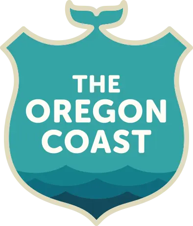 Stylized logo for "The Oregon Coast" featuring a teal shield design with a whale tail at the top. The words "THE OREGON COAST" are centered in bold white uppercase letters, with a layered graphic of ocean waves in varying shades of blue at the bottom of the shield. The logo is bordered in a light tan outline.