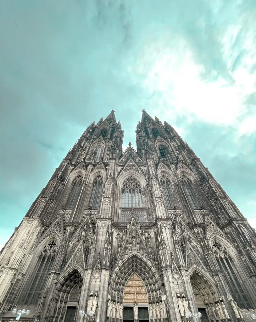 A low-angle view of the stunning St. Vitus Cathedral in Prague, showcasing its intricate Gothic architecture against a cloudy sky.