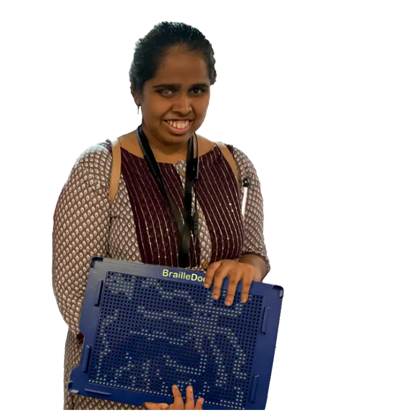 A person stands holding a BrailleDot device, wearing a patterned top, with a lanyard visible around their neck.