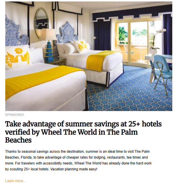 An interior shot of a hotel room with two beds. The room is decorated in a blue and white theme with yellow accents. Large sliding glass doors open onto a balcony, and the floor is covered with a blue patterned rug.
