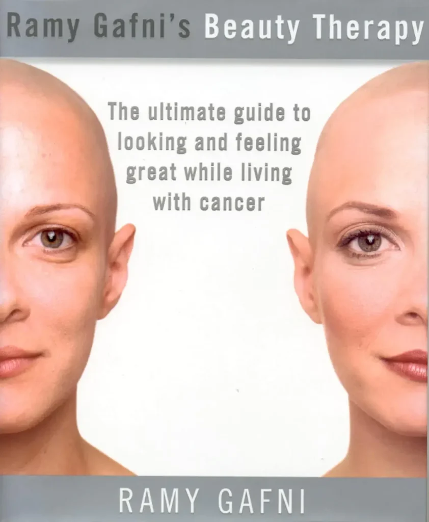 The cover of a book titled "Ramy Gafni's Beauty Therapy." The subtitle reads: "The ultimate guide to looking and feeling great while living with cancer." The image shows two halves of a woman's head facing out, both with shaven heads (suggesting hair loss from chemotherapy) but one side showing a face with natural-looking eyebrows and subtle makeup, illustrating the techniques discussed. The author's name, RAMY GAFNI, is at the bottom.