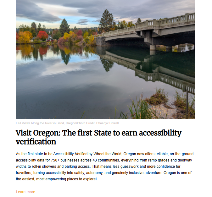 A scenic landscape photo taken in the fall. A wide, smooth river with calm water runs from the foreground into the background, reflecting the colorful autumn trees (red, orange, and green) lining the far bank. A concrete bridge with arched supports crosses the river in the upper right. The photo illustrates a news story with the headline: "Visit Oregon: The first State to earn accessibility verification."