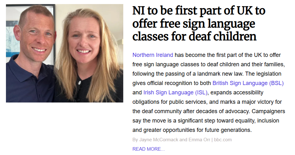 Close-up portrait of a smiling man and woman standing together indoors for a news article about UK sign language legislation.